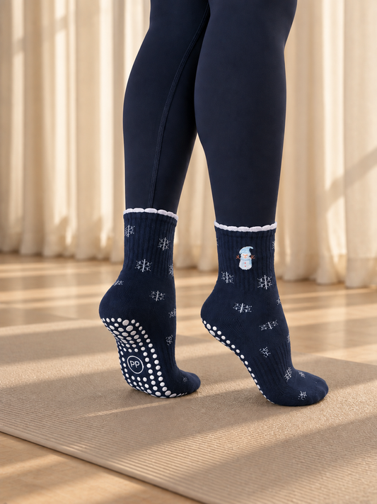 Pilates People Winter Wonderland dark blue grip socks with snowflakes, snowmen and white scalloped cuff — view 1