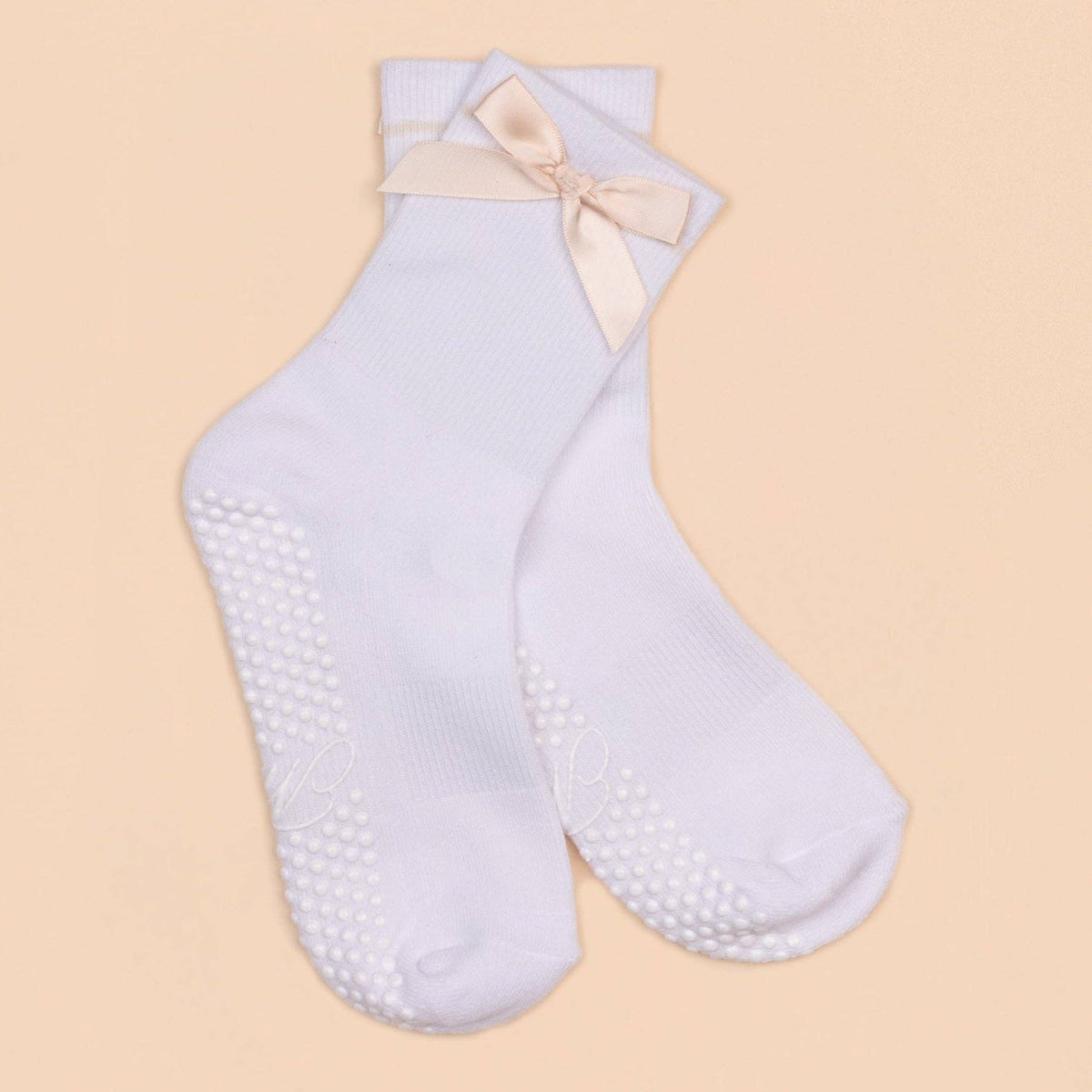 White Maison Joie grip socks with peach satin bow and white dot soles