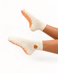 Pumpkin-shaped non-slip grips on cream Grounded studio socks