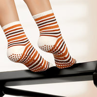 Elliosa Autumn Stripe Grip Socks in Golden Hour - worn on a reformer