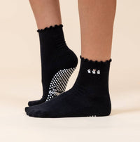 Maison Joie Ghost Ruffle black grip socks worn with white traction