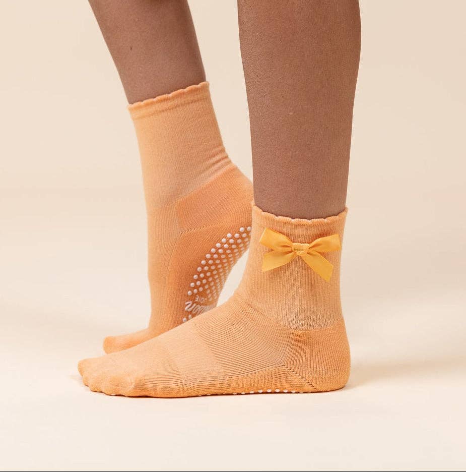 Maison Joie The Original orange grip socks worn with satin bow and white traction