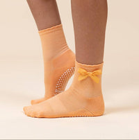 Maison Joie The Original orange grip socks worn with satin bow and white traction