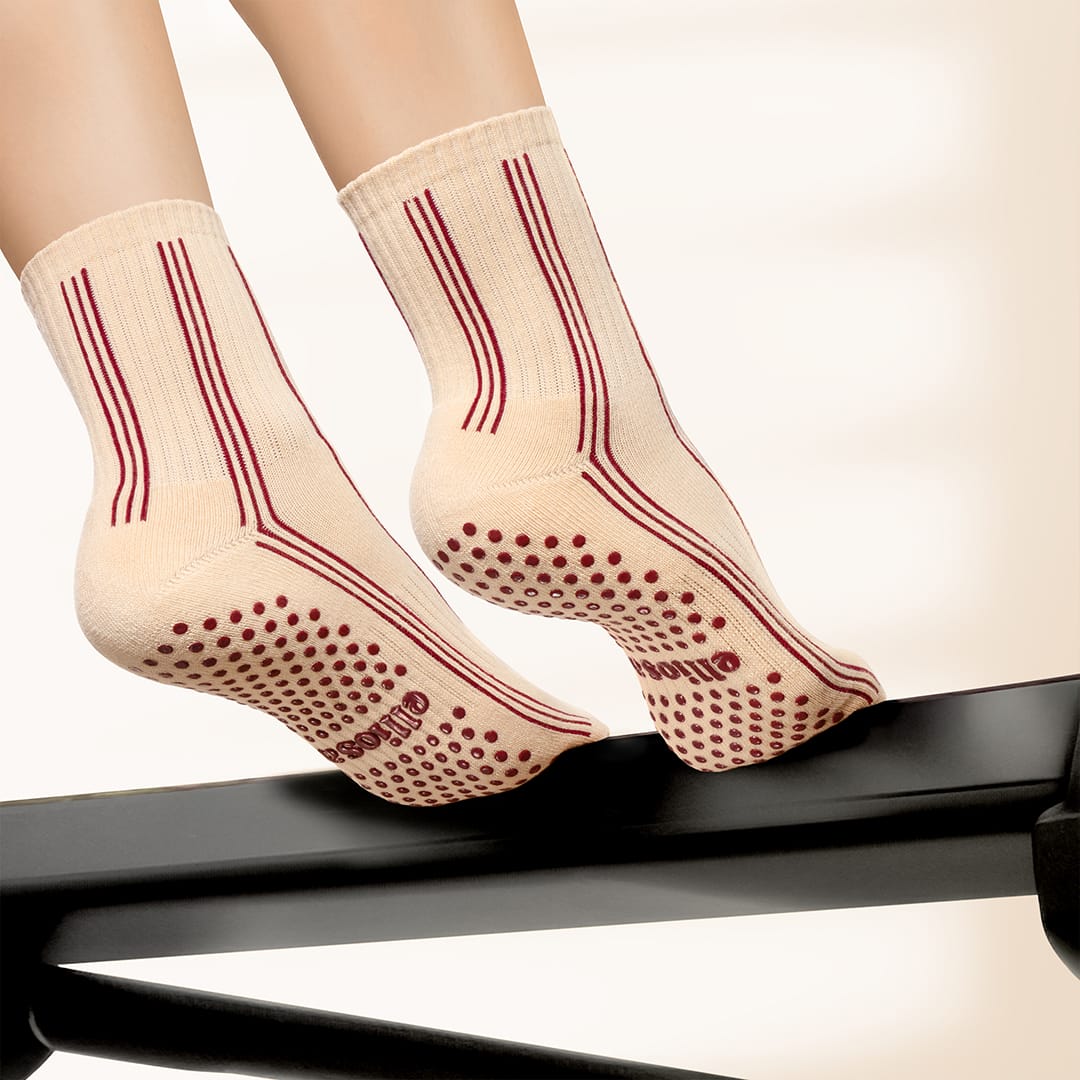 Elliosa Pinstripes Burgundy Caramel grip socks on a Pilates reformer