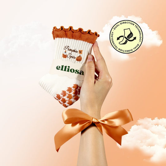 Cream Elliosa Pumpkin Spice grip socks with orange ruffle cuffs and pumpkin embroidery