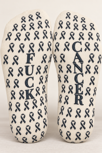 Close view of Fuck Cancer ribbon grip pattern on cream crew socks