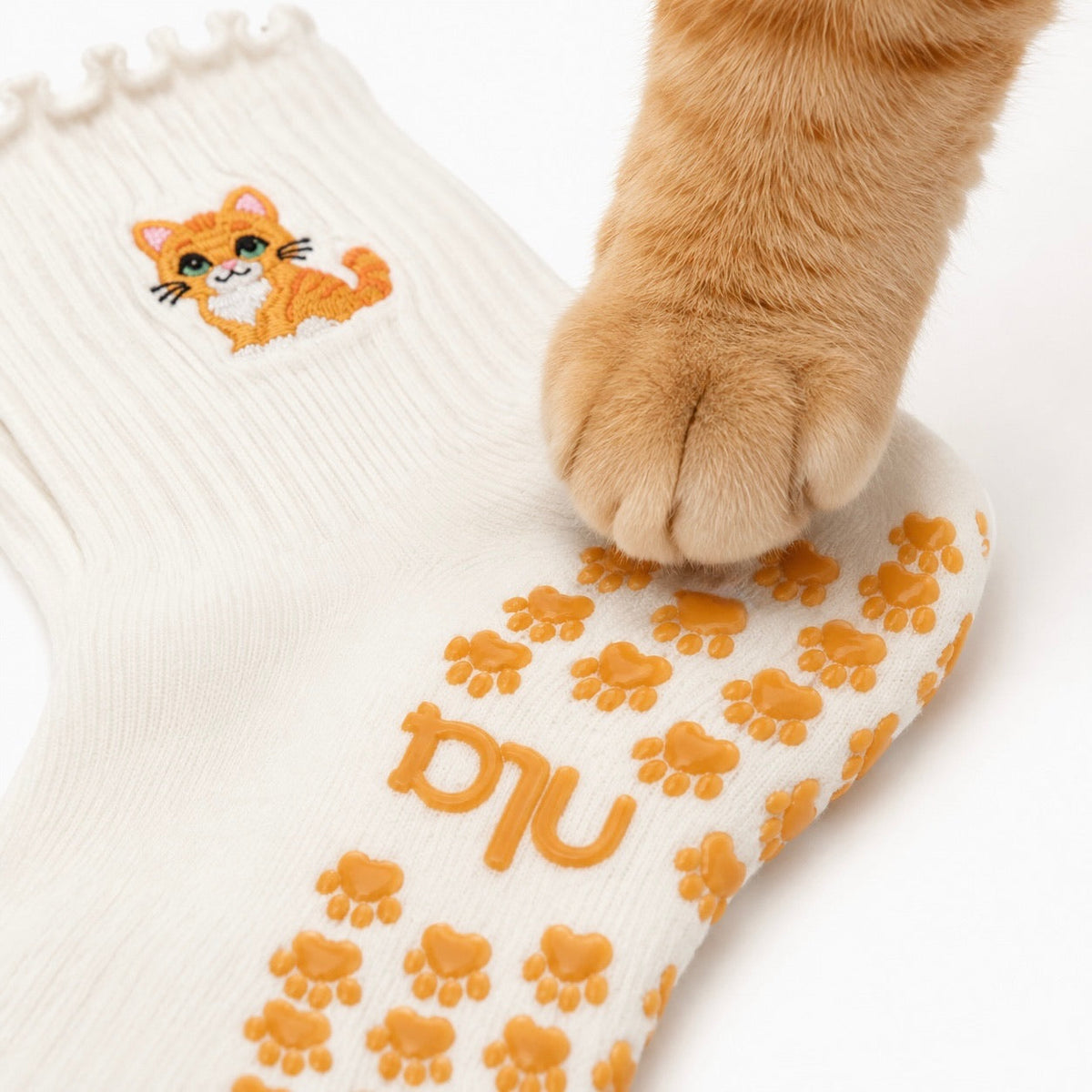 Close-up of embroidered orange tabby and ruffle cuff