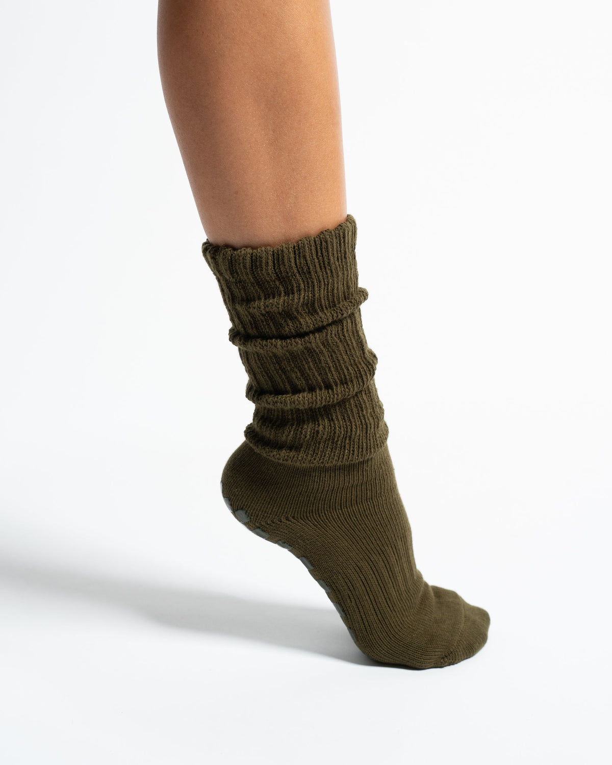 The Slouch Olive grip sock worn in a scrunched style